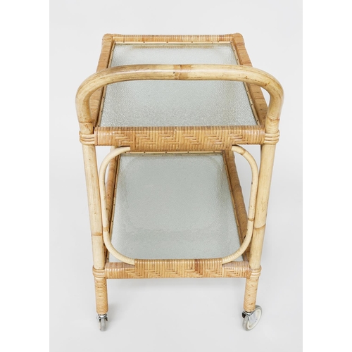 107 - TEA TROLLEY, mid 20th century rattan framed and cane bound with two ripple glass shelves and castors... 