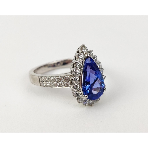 11 - AN 18CT WHITE GOLD TANZANITE AND DIAMOND SET DRESS RING, the single pear shaped mixed cut stone surr... 