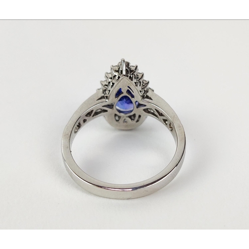 11 - AN 18CT WHITE GOLD TANZANITE AND DIAMOND SET DRESS RING, the single pear shaped mixed cut stone surr... 