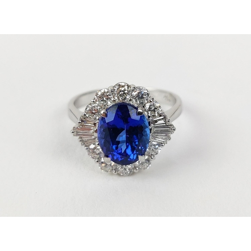 12 - AN 18CT WHITE GOLD TANZANITE AND DIAMOND DRESS RING, the central tanzanite stone surrounded by brill... 