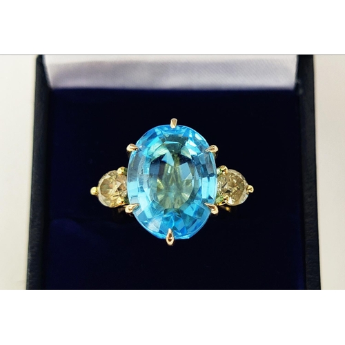 13 - AN 18CT YELLOW GOLD BLUE TOPAZ AND DIAMOND DRESS RING, the central mixed cut topaz of approximately ... 