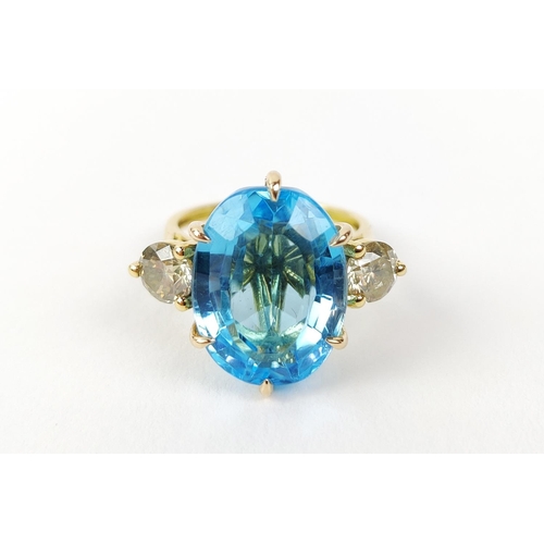 13 - AN 18CT YELLOW GOLD BLUE TOPAZ AND DIAMOND DRESS RING, the central mixed cut topaz of approximately ... 