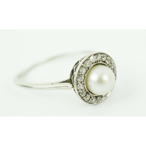 17 - A PLATINUM PEARL AND DIAMOND DRESS RING, set with a central pearl surrounded by small round old mine... 