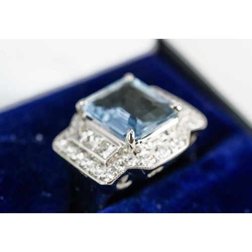 21 - AN 18CT WHITE GOLD AQUAMARINE AND DIAMOND, the central emerald-cut aquamarine surrounded by princess... 