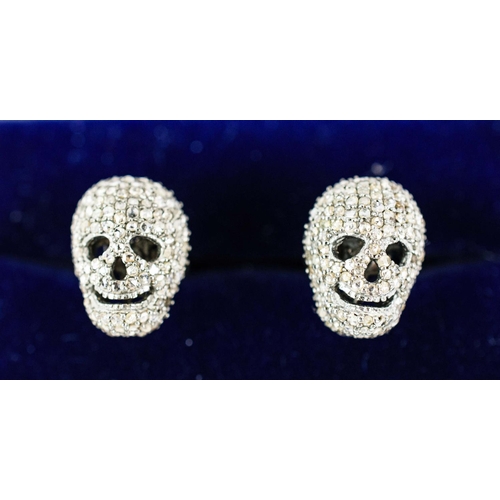 31 - A PAIR OF SKULL SHAPED CUFFLINKS, white metal and set with diamonds, complete with box