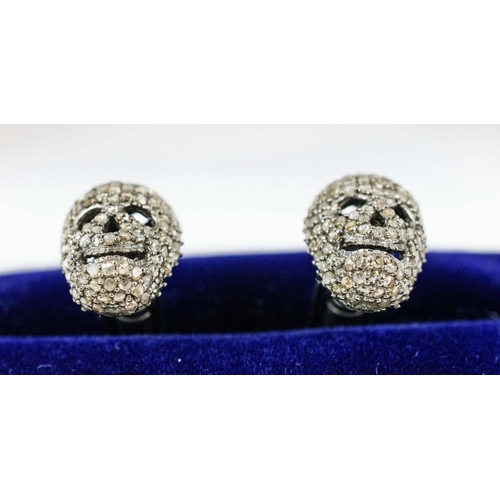 31 - A PAIR OF SKULL SHAPED CUFFLINKS, white metal and set with diamonds, complete with box