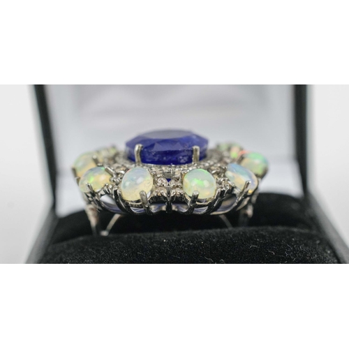 33 - A LARGE OVAL TANZANITE, OPAL AND DIAMOND COCKTAIL RING, the central oval mixed cut tanzanite surroun... 