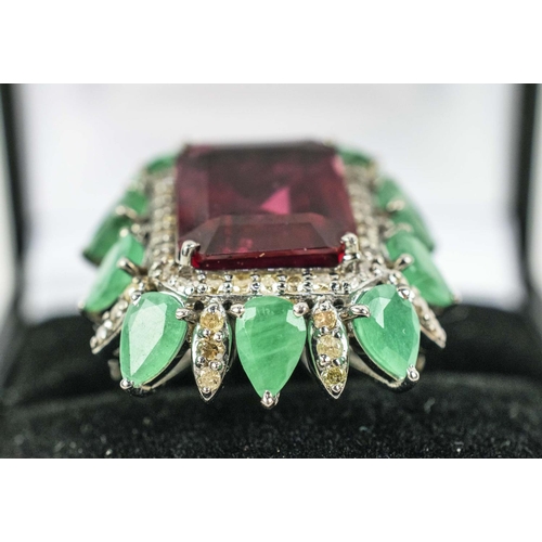 36 - A TOURMALINE, EMERALD AND DIAMOND DRESS RING, the central purple step cut tourmaline surrounded by a... 