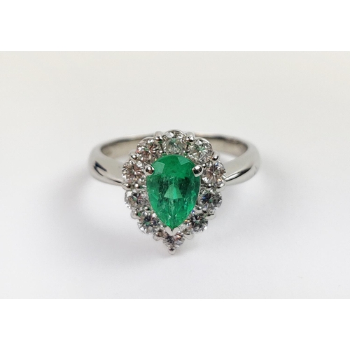 18 - A PLATINUM EMERALD AND DIAMOND DRESS RING, the pear shaped emerald surrounded by a border of ten dia... 