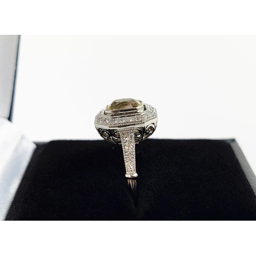 27 - A PLATINUM YELLOW SAPPHIRE AND DIAMOND SET RING, the central mixed cut stone surrounded by a halo of... 