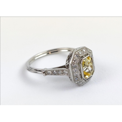 27 - A PLATINUM YELLOW SAPPHIRE AND DIAMOND SET RING, the central mixed cut stone surrounded by a halo of... 