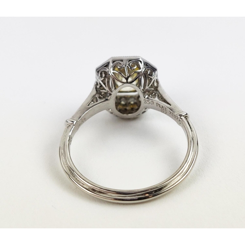 27 - A PLATINUM YELLOW SAPPHIRE AND DIAMOND SET RING, the central mixed cut stone surrounded by a halo of... 