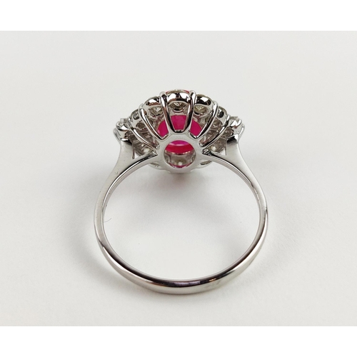 28 - A 18CT WHITE GOLD RUBY AND DIAMOND RING, the oval mixed cut ruby surrounded by a halo of round brill... 