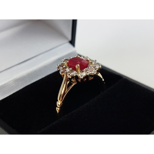 31 - A 9CT YELLOW GOLD RUBY AND DIAMOND RING, the mixed cut ruby of approximately 1 carat, surrounded by ... 