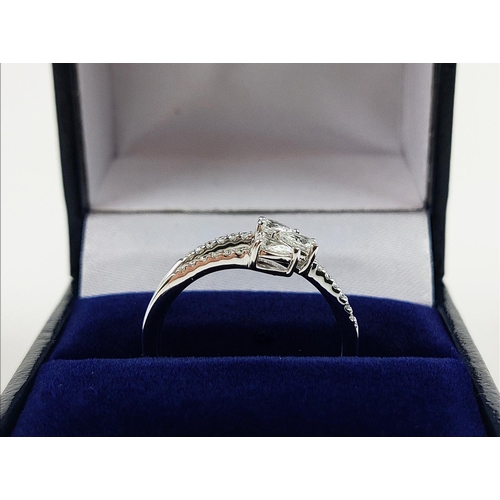 35 - A 9CT WHITE GOLD DIAMOND RING, with three main pear shaped diamonds, diamond set shoulders, total di... 