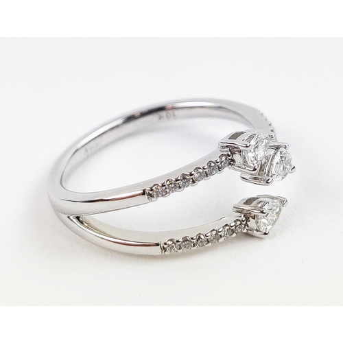 35 - A 9CT WHITE GOLD DIAMOND RING, with three main pear shaped diamonds, diamond set shoulders, total di... 