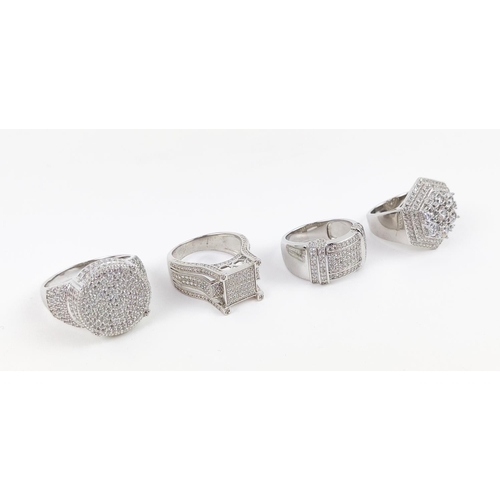 36 - A COLLECTION OF FOUR STERLING SILVER DRESS RINGS, set with clusters of CZs, various styles, in vario... 