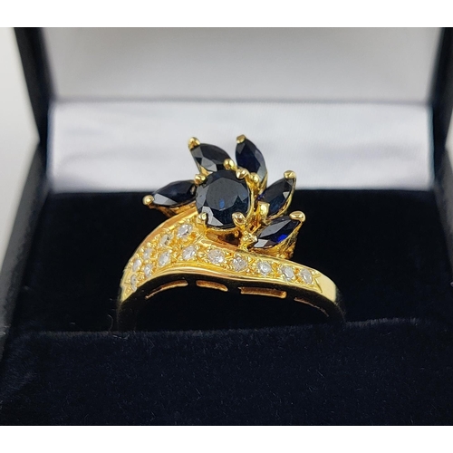 38 - A YELLOW METAL SAPPHIRE AND DIAMOND SET DRESS RING, probably 18ct gold, asymmetrical floral spray wi... 