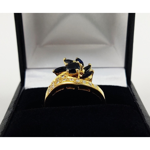 38 - A YELLOW METAL SAPPHIRE AND DIAMOND SET DRESS RING, probably 18ct gold, asymmetrical floral spray wi... 