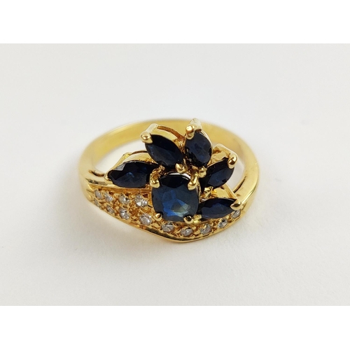 38 - A YELLOW METAL SAPPHIRE AND DIAMOND SET DRESS RING, probably 18ct gold, asymmetrical floral spray wi... 