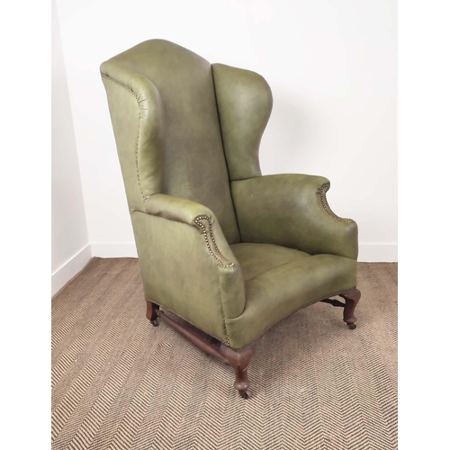 396 - WING ARMCHAIR, Victorian mahogany in green leather on steel castors, 132cm H x 79cm W x 95cm D.