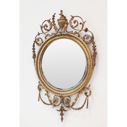 379 - WALL MIRROR, circular gilt wood with Adam style urn detail, with a bevelled plate, 93cm H x 60cm W.