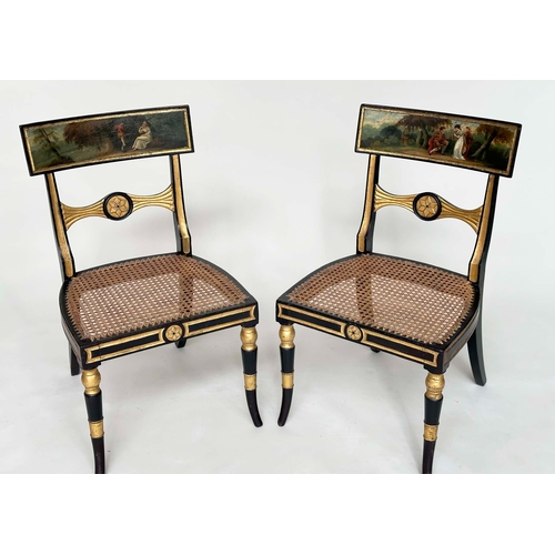 194 - REGENCY SIDE CHAIRS, a pair, ebonised and parcel gilt each with hand painted bow back rail and cane ... 