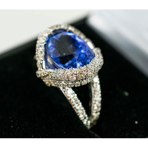 44 - AN 18CT WHITE GOLD SAPPHIRE AND DIAMOND SET DRESS RING, the central mixed cut sapphire surround by a... 