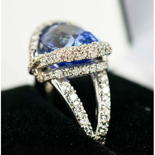 44 - AN 18CT WHITE GOLD SAPPHIRE AND DIAMOND SET DRESS RING, the central mixed cut sapphire surround by a... 