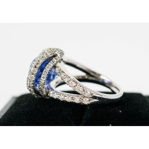 44 - AN 18CT WHITE GOLD SAPPHIRE AND DIAMOND SET DRESS RING, the central mixed cut sapphire surround by a... 