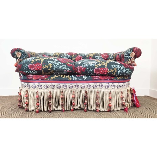 367 - SOFA, of curved form, with a button back, in a polychrome woven fabric with extensive swags and tass... 