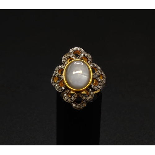 35 - A MOONSTONE AND DIAMOND COCKTAIL RING, the cabouchon moonstone of approximately 3.98 carats, surroun... 