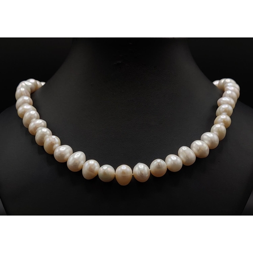 37 - A FRESHWATER WHITE PEARL SINGLE STRAND NECKLACE, fitted with 14mm oval pearls, on a 9ct yellow gold ... 