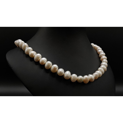 37 - A FRESHWATER WHITE PEARL SINGLE STRAND NECKLACE, fitted with 14mm oval pearls, on a 9ct yellow gold ... 