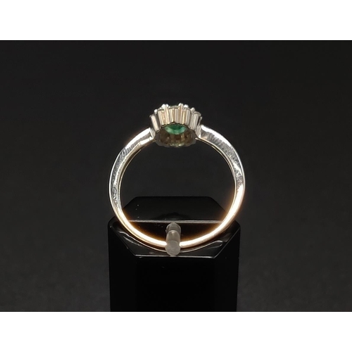 32 - AN 18CT WHITE GOLD EMERALD AND DIAMOND RING, the central oval cut emerald of approximately 0.45 cara... 