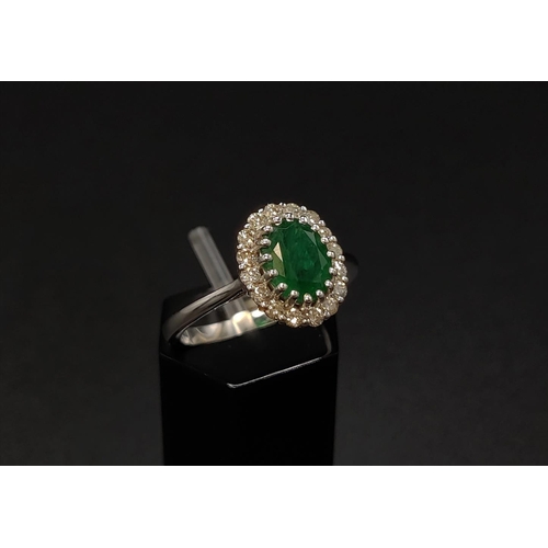 39 - AN 18CT WHITE GOLD EMERALD AND DIAMOND CLUSTER RING, the central oval cut emerald of approximately 1... 