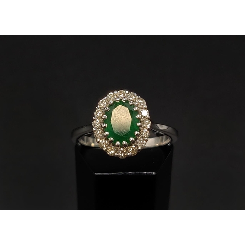 39 - AN 18CT WHITE GOLD EMERALD AND DIAMOND CLUSTER RING, the central oval cut emerald of approximately 1... 