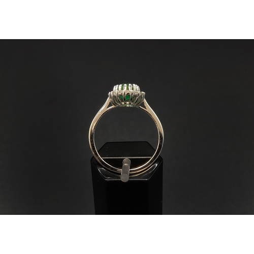 39 - AN 18CT WHITE GOLD EMERALD AND DIAMOND CLUSTER RING, the central oval cut emerald of approximately 1... 