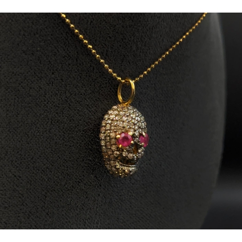 35 - A RUBY AND DIAMOND SET SKULL PENDANT NECKLACE, silver gilt frame, fitted on a silver-gilt chain, 45c... 