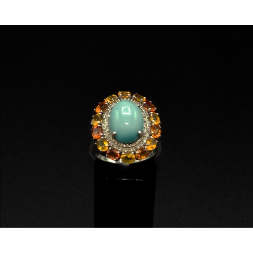 37 - A TURQUOISE AND FANCY COLOURED SAPPHIRE SET DRESS RING, the central cabouchon surrounded by diamonds... 