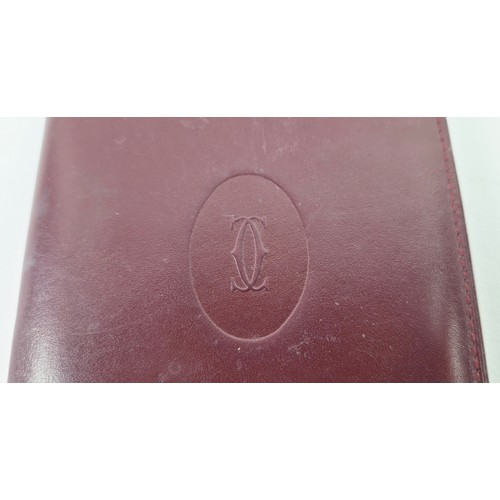 27A - CARTIER WALLET, iconic burgundy colour leather with matching fabric monogram lining, gold tone hardw... 