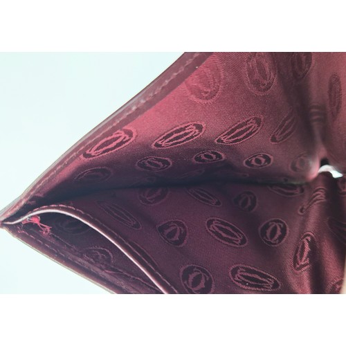 27A - CARTIER WALLET, iconic burgundy colour leather with matching fabric monogram lining, gold tone hardw... 