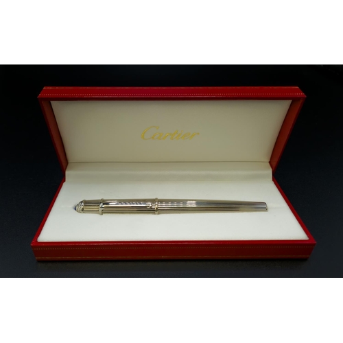 63 - A CARTIER STAINLESS STEEL FOUNTAIN PEN, with an 18ct white gold nib, blue resin cabochon to cap term... 