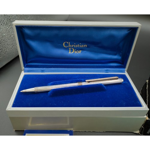 58 - A TIFFANY & CO SILVER BALLPOINT PEN, with an extra replaceable cartridge, a Christian Dior pencil, a... 