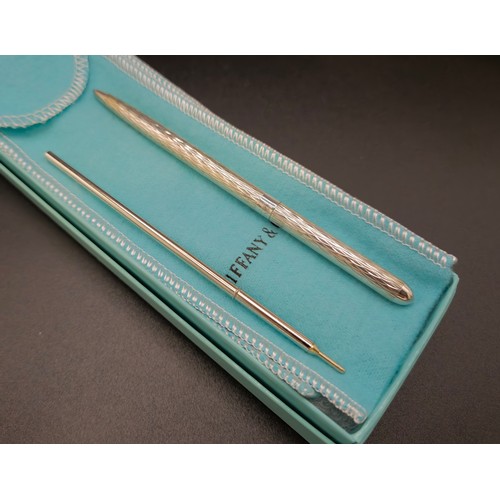 58 - A TIFFANY & CO SILVER BALLPOINT PEN, with an extra replaceable cartridge, a Christian Dior pencil, a... 