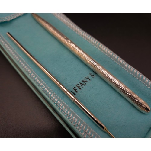 58 - A TIFFANY & CO SILVER BALLPOINT PEN, with an extra replaceable cartridge, a Christian Dior pencil, a... 