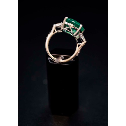 40 - 18CT WHITE GOLD EMERALD AND DIAMOND TRILOGY RING, the cushion mixed cut central emerald of 8.22 cara... 