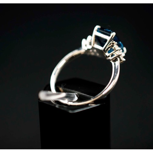 48 - PLATINUM TOPAZ AND DIAMOND RING, the central London blue topaz flanked by baguette cut diamonds, the... 