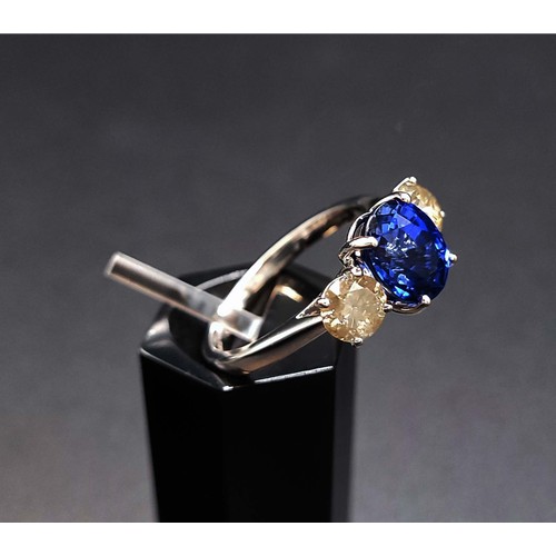 37 - 18CT WHITE GOLD DIAMOND AND SYNTHETIC SAPPHIRE TRILOGY RING, the central mixed cut sapphire flanked ... 