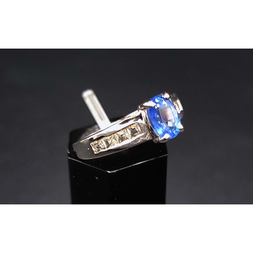 39 - 9CT WHITE GOLD KYANITE AND WHITE STONE DRESS RING, the oval stone set flanked by eight square cut st... 